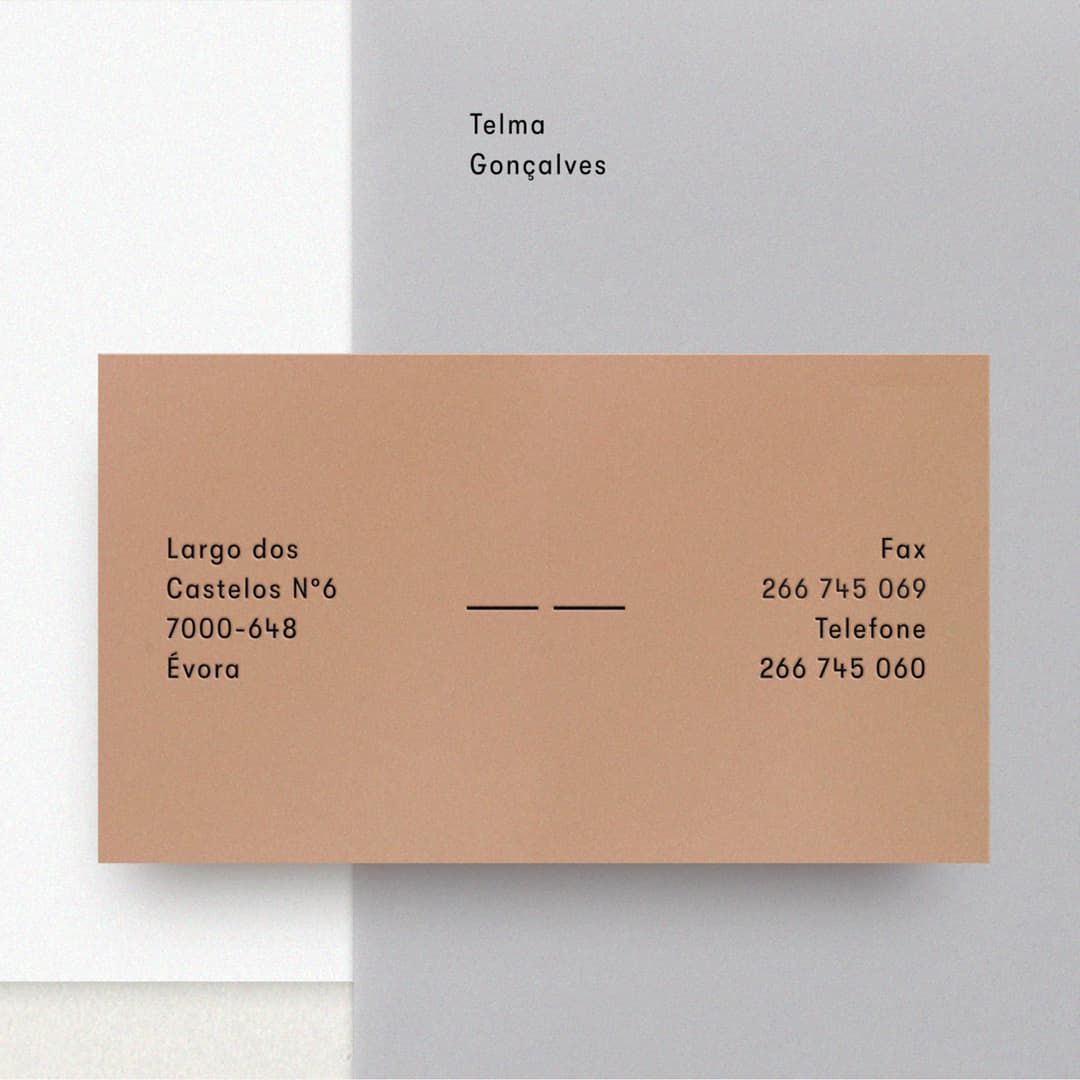 Bege business card with black typography on top of grey envelope